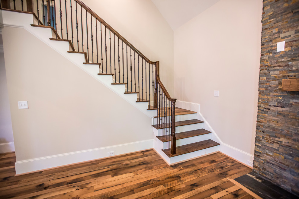 Photo of a large transitional wood l-shaped staircase in Atlanta with painted wood risers.