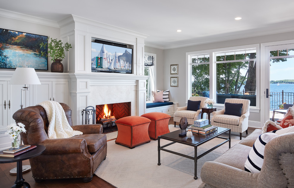 Large open concept living room in Minneapolis with beige walls, medium hardwood floors, a standard fireplace and a wall-mounted tv.