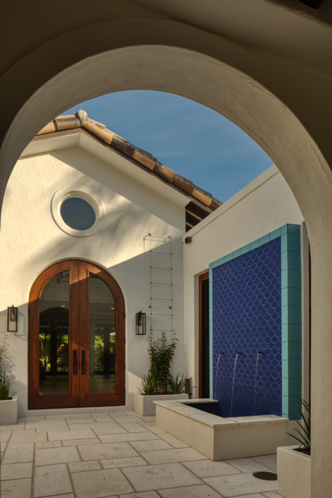 Inspiration pour une entrée méditerranéenne avec un mur bleu et un sol en carrelage de céramique.