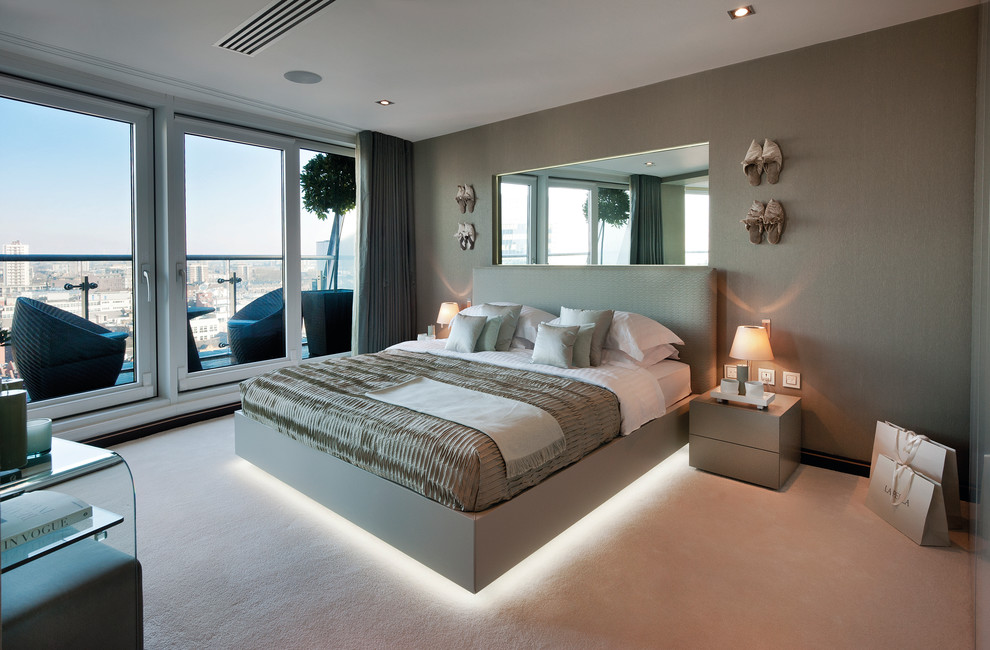 Mid-sized contemporary bedroom in London with grey walls and carpet.