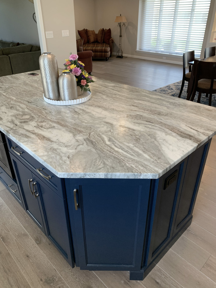 Inspiration for a large transitional l-shaped vinyl floor and gray floor eat-in kitchen remodel with an undermount sink, recessed-panel cabinets, white cabinets, quartz countertops, gray backsplash, ceramic backsplash, stainless steel appliances, an island and white countertops