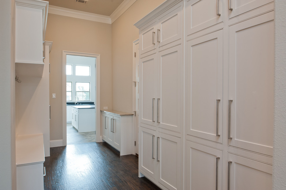 This is an example of a large transitional u-shaped utility room in Dallas with an undermount sink, recessed-panel cabinets, white cabinets, granite benchtops, beige walls, dark hardwood floors, brown floor and beige benchtop.