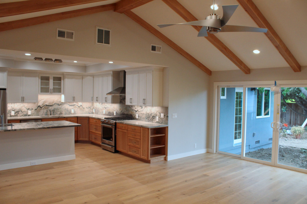 Kitchen - large transitional l-shaped medium tone wood floor, brown floor and vaulted ceiling kitchen idea in San Francisco with an undermount sink, shaker cabinets, medium tone wood cabinets, granite countertops, multicolored backsplash, stone slab backsplash, stainless steel appliances, an island and multicolored countertops