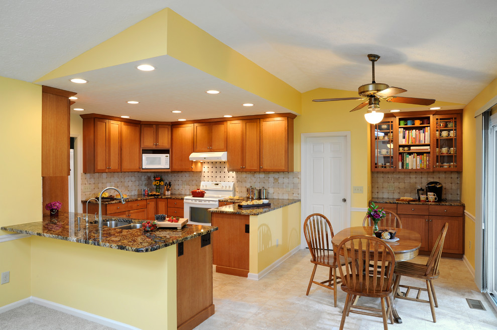 Mid-sized transitional u-shaped limestone floor and beige floor eat-in kitchen photo in Cincinnati with a double-bowl sink, shaker cabinets, medium tone wood cabinets, granite countertops, beige backsplash, ceramic backsplash, stainless steel appliances and a peninsula