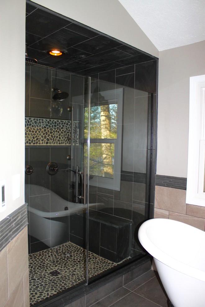 Inspiration for a mid-sized transitional master bathroom in Indianapolis with furniture-like cabinets, dark wood cabinets, a claw-foot tub, a double shower, a two-piece toilet, pebble tile, grey walls, porcelain floors, engineered quartz benchtops and a vessel sink.
