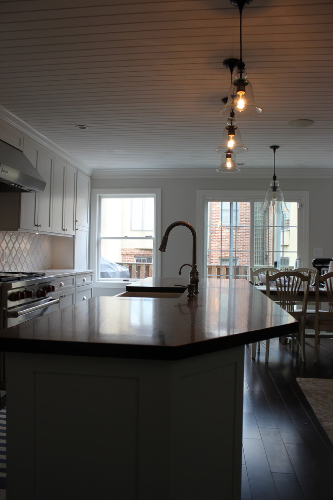 Inspiration for a large transitional galley dark wood floor eat-in kitchen remodel in Baltimore with a farmhouse sink, shaker cabinets, white cabinets, wood countertops, white backsplash, ceramic backsplash, stainless steel appliances and an island