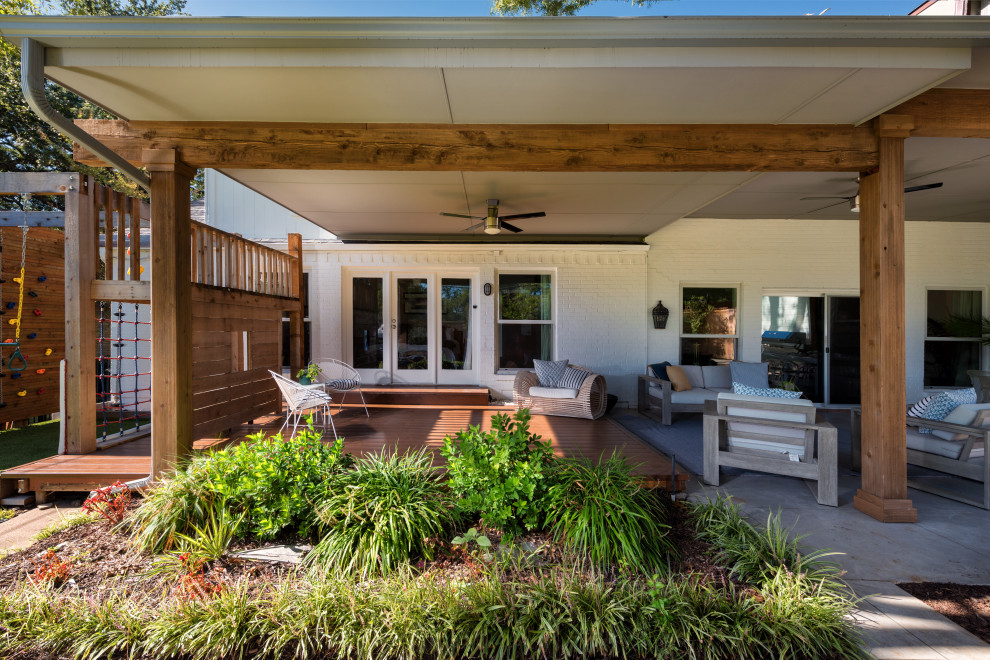Inspiration for a mid-sized modern backyard patio in Dallas with a roof extension and decking.