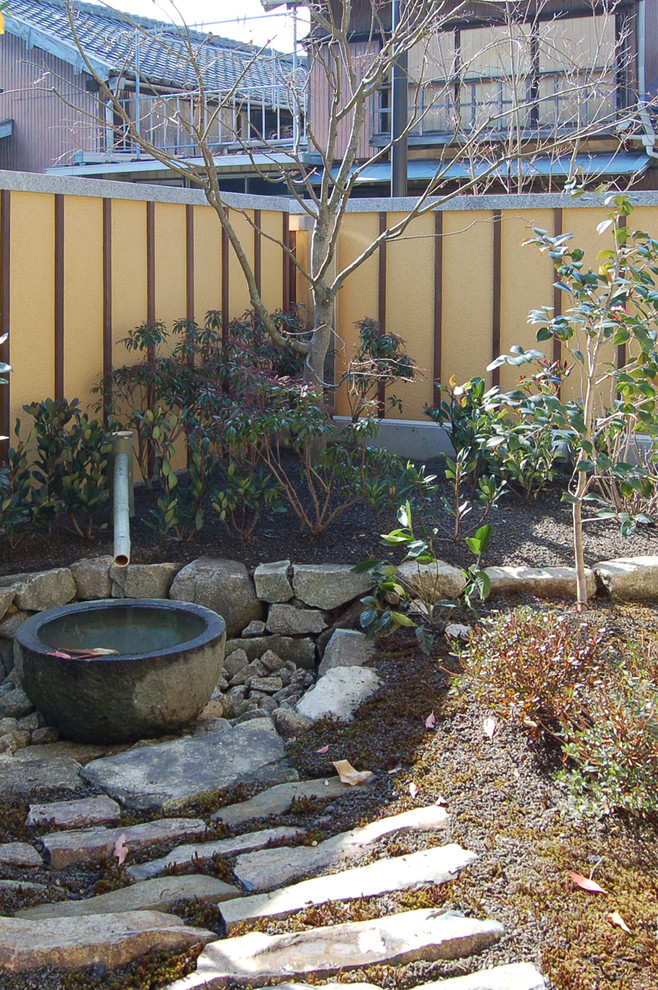 This is an example of an asian courtyard patio in Other with natural stone pavers.