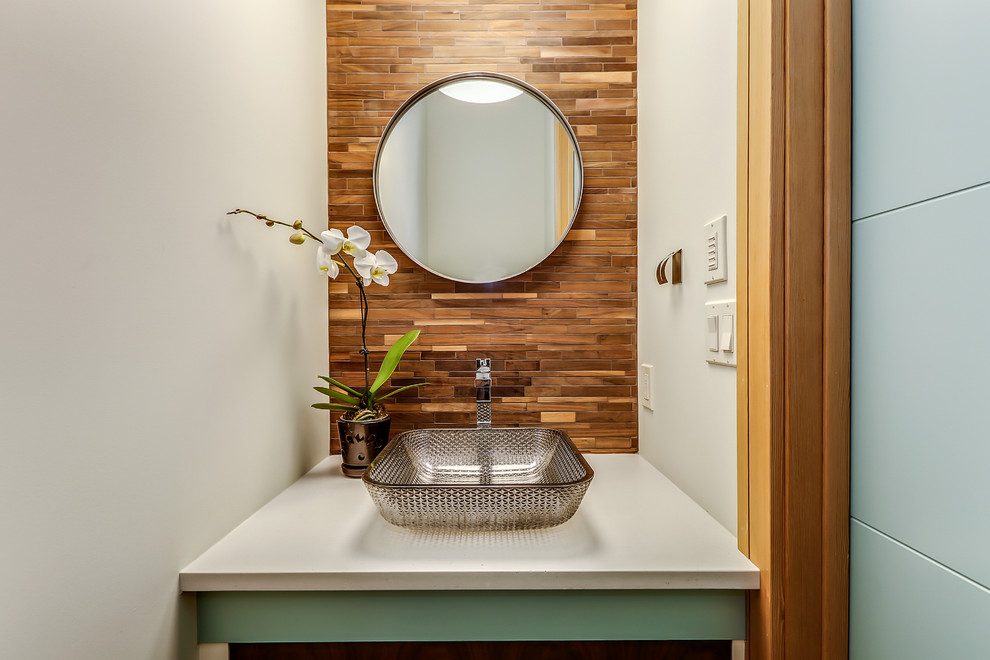 Mid-sized midcentury powder room in Calgary with furniture-like cabinets, turquoise cabinets, a two-piece toilet, brown tile, matchstick tile, white walls, medium hardwood floors, a vessel sink, brown floor and engineered quartz benchtops.