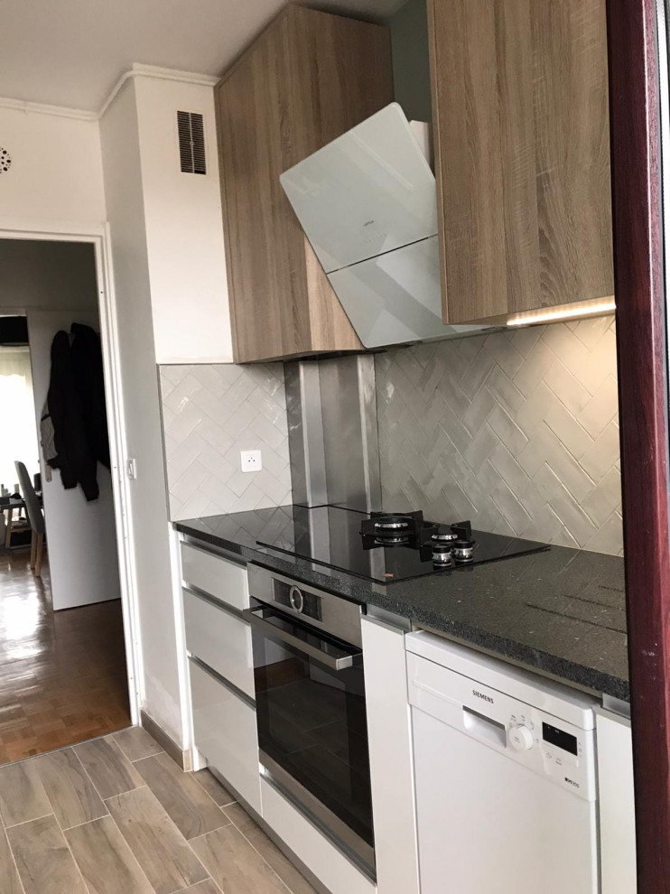 Photo of a mid-sized scandinavian galley separate kitchen in Paris with a single-bowl sink, beaded inset cabinets, light wood cabinets, granite benchtops, grey splashback, subway tile splashback, stainless steel appliances, light hardwood floors, no island, brown floor and grey benchtop.