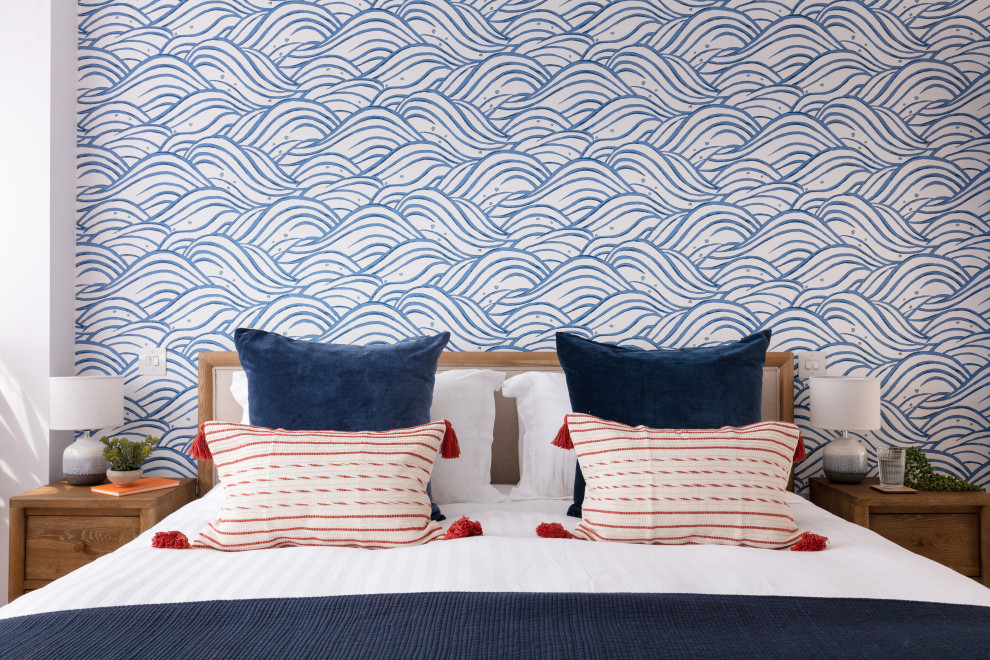 На фото: хозяйская спальня среднего размера в морском стиле с синими стенами, ковровым покрытием, бежевым полом, обоями на стенах и акцентной стеной без камина с
