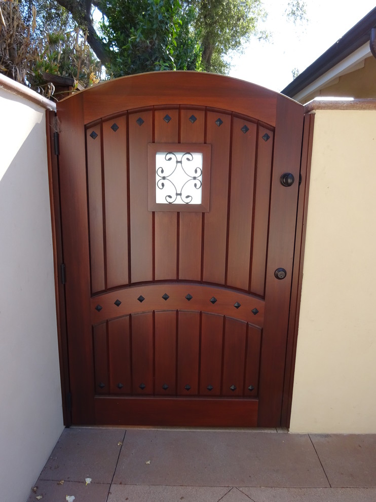 Photo of a mid-sized mediterranean front door in Los Angeles with a single front door, a medium wood front door and white walls.