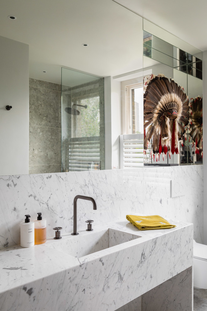 This is an example of a mid-sized scandinavian kids bathroom in London with an open shower, a wall-mount toilet, marble, white walls, an undermount sink, marble benchtops and white benchtops.