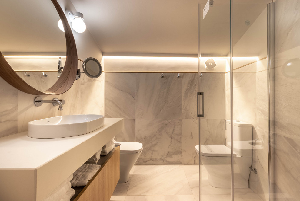 Inspiration for a mid-sized scandinavian master wet room bathroom in Bilbao with recessed-panel cabinets, white cabinets, a bidet, black and white tile, marble, white walls, ceramic floors, an integrated sink, solid surface benchtops, white floor, a sliding shower screen and white benchtops.