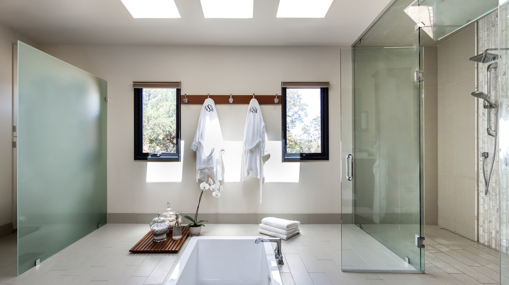 Photo of a large contemporary master bathroom in Los Angeles with a drop-in tub, a curbless shower, beige tile, beige walls, porcelain floors, mosaic tile, beige floor and a hinged shower door.