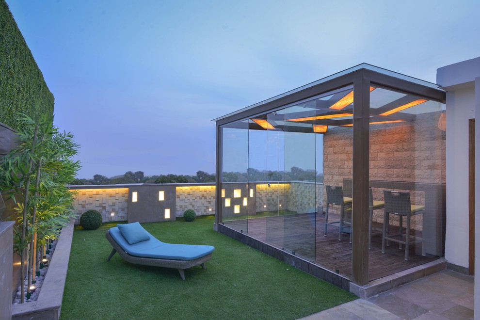 Mid-sized contemporary rooftop partial sun garden in Delhi with concrete pavers.