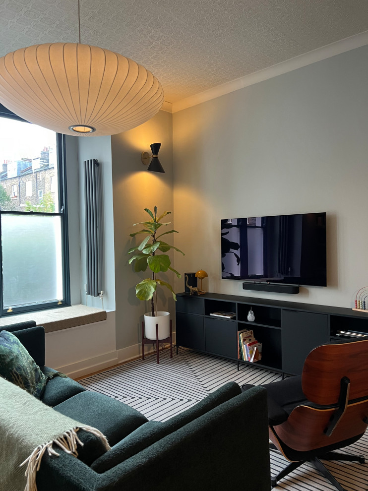 Cette image montre un grand salon design ouvert avec un mur vert, un sol en bois brun et un sol marron.