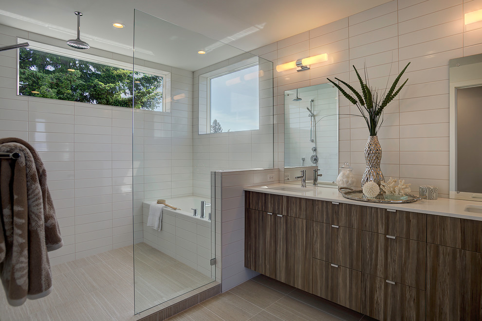 This is an example of a contemporary wet room bathroom in Seattle with flat-panel cabinets, dark wood cabinets, an alcove tub, an undermount sink, beige floor and white benchtops.