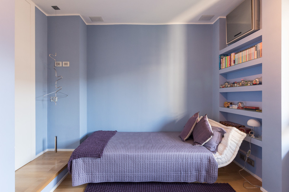 This is an example of a mid-sized contemporary guest bedroom in Milan with light hardwood floors.