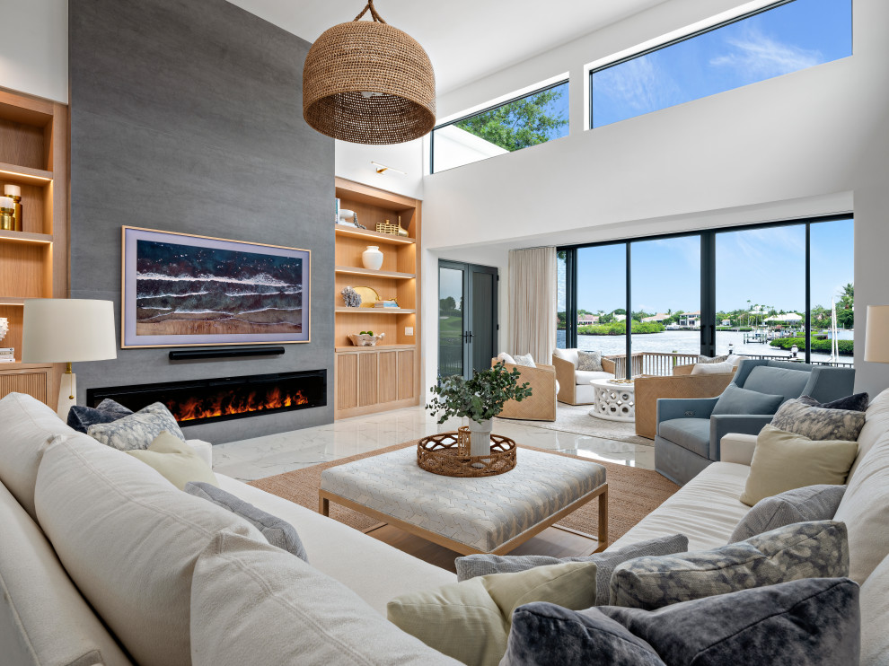 Large beach style open concept family room in Miami with a stone fireplace surround and a wall-mounted tv.