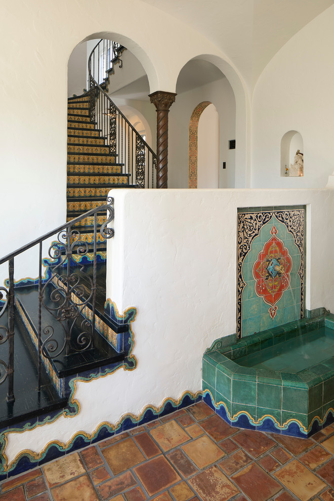 Inspiration for an expansive mediterranean foyer in Los Angeles with white walls, terra-cotta floors, a single front door and a blue front door.