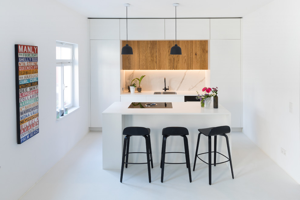 Inspiration for a mid-sized contemporary single-wall open plan kitchen in Stuttgart with an undermount sink, light wood cabinets, laminate benchtops, black appliances, with island, white floor, white benchtop, flat-panel cabinets and white splashback.