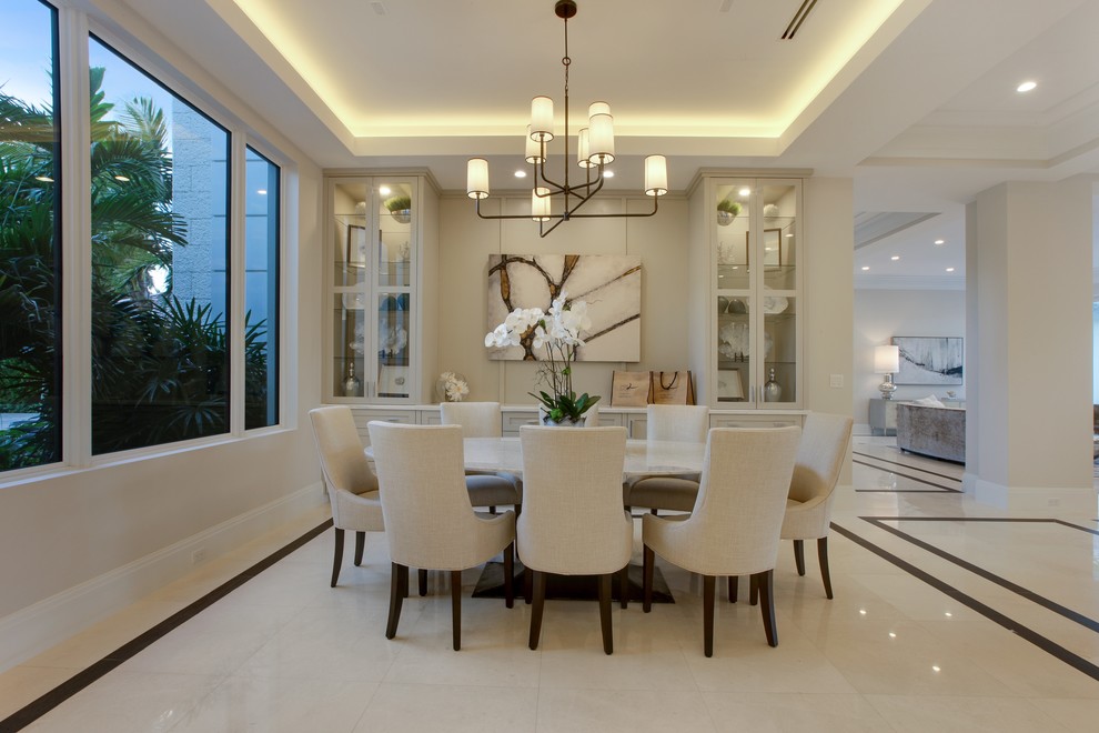 Photo of a transitional dining room in Miami with beige walls and white floor.