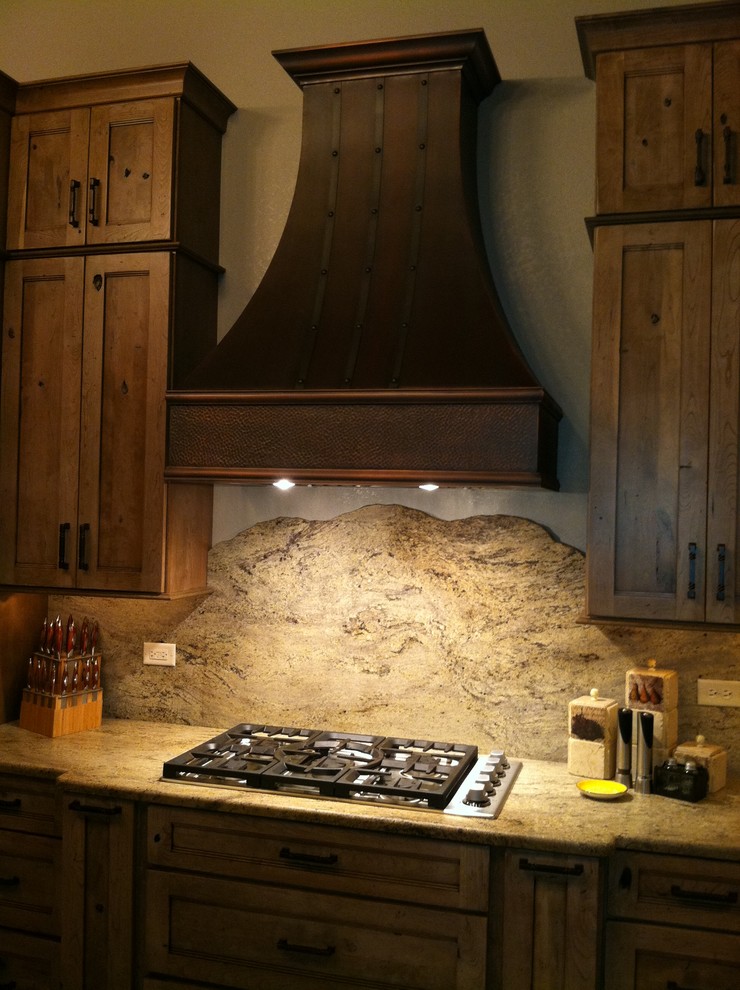Open concept kitchen - large rustic l-shaped porcelain tile open concept kitchen idea in Chicago with a farmhouse sink, recessed-panel cabinets, medium tone wood cabinets, granite countertops, beige backsplash, stone slab backsplash, stainless steel appliances and an island