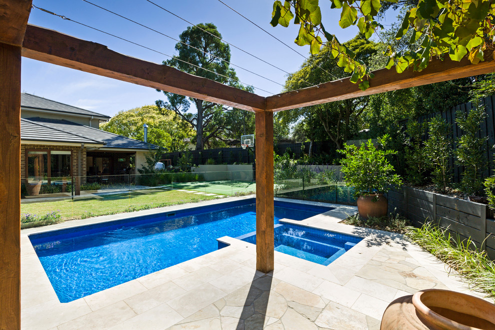 Inspiration for a mid-sized mediterranean backyard rectangular lap pool in Melbourne with a pool house and natural stone pavers.