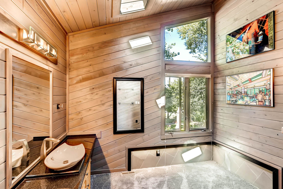Mid-sized mountain style master black tile and cement tile concrete floor corner shower photo in Denver with flat-panel cabinets, light wood cabinets, a one-piece toilet, brown walls, a vessel sink and quartzite countertops