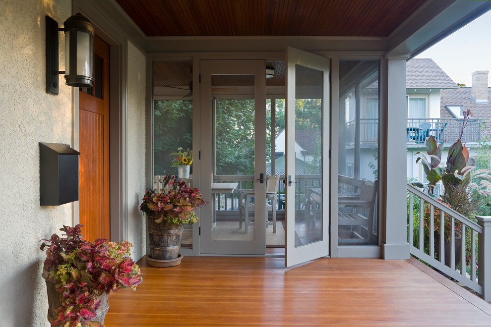 Photo of a traditional screened-in verandah in Minneapolis with decking and a roof extension.