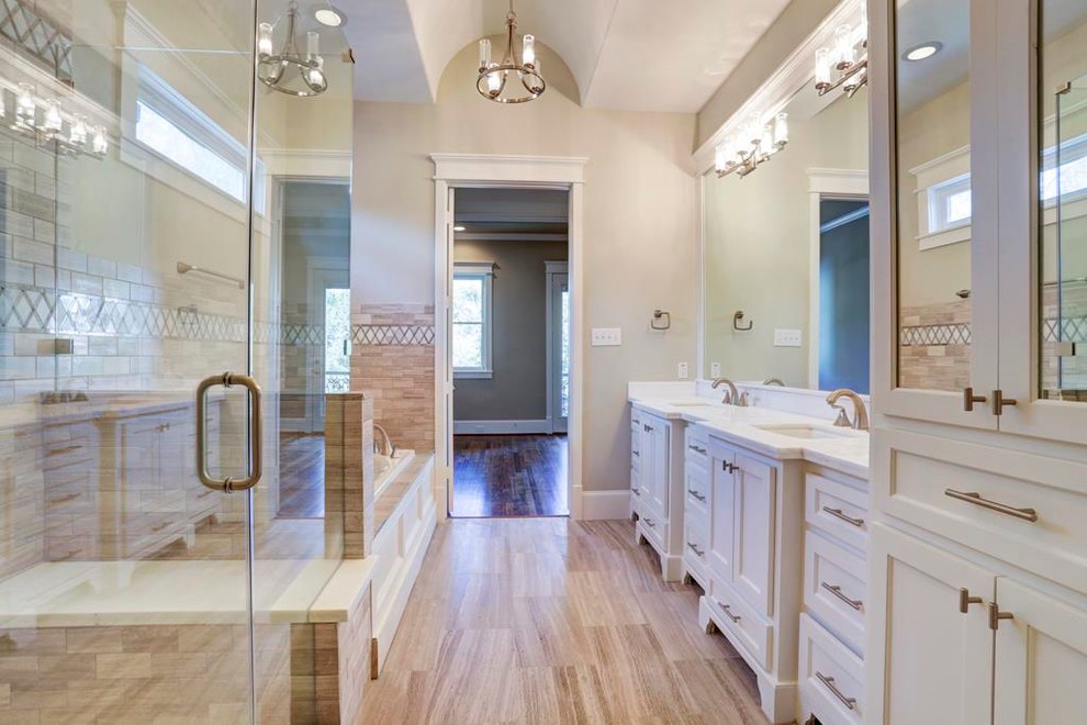 Photo of a mid-sized traditional master bathroom in Houston with an undermount sink, recessed-panel cabinets, white cabinets, granite benchtops, a drop-in tub, an open shower, a two-piece toilet, brown tile, cement tile, beige walls, travertine floors, brown floor and a hinged shower door.