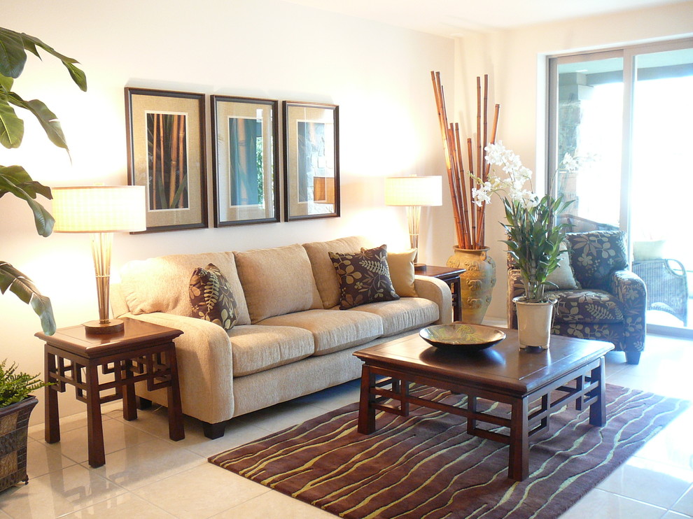 Photo of a mid-sized tropical living room in Hawaii with beige walls, limestone floors, no fireplace and beige floor.