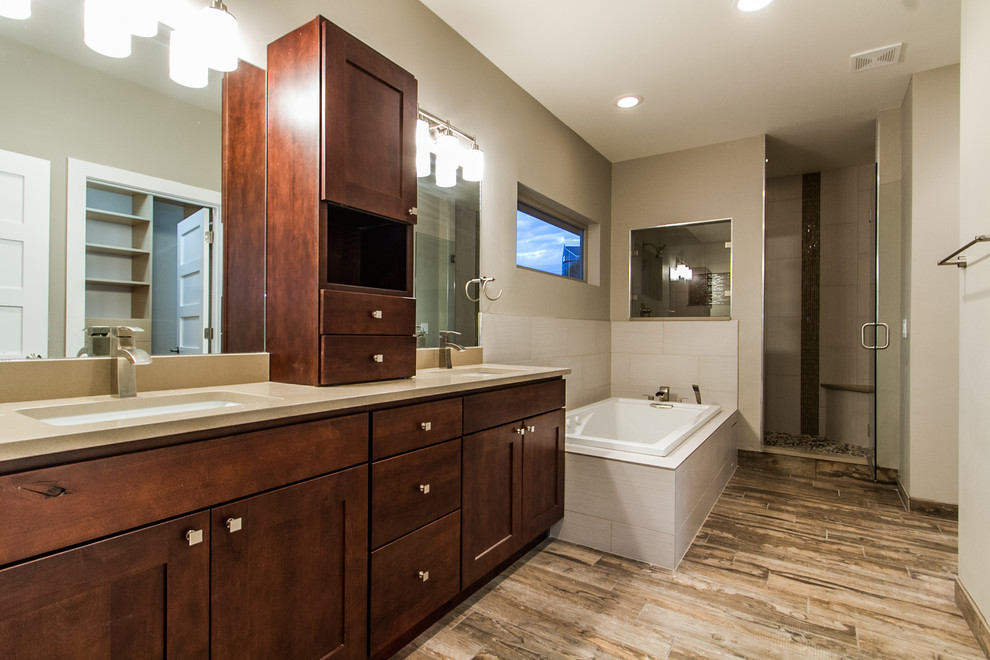 Design ideas for a mid-sized modern master bathroom in Denver with an undermount sink, shaker cabinets, medium wood cabinets, quartzite benchtops, a drop-in tub, an alcove shower, a one-piece toilet, brown tile, porcelain tile, grey walls and porcelain floors.