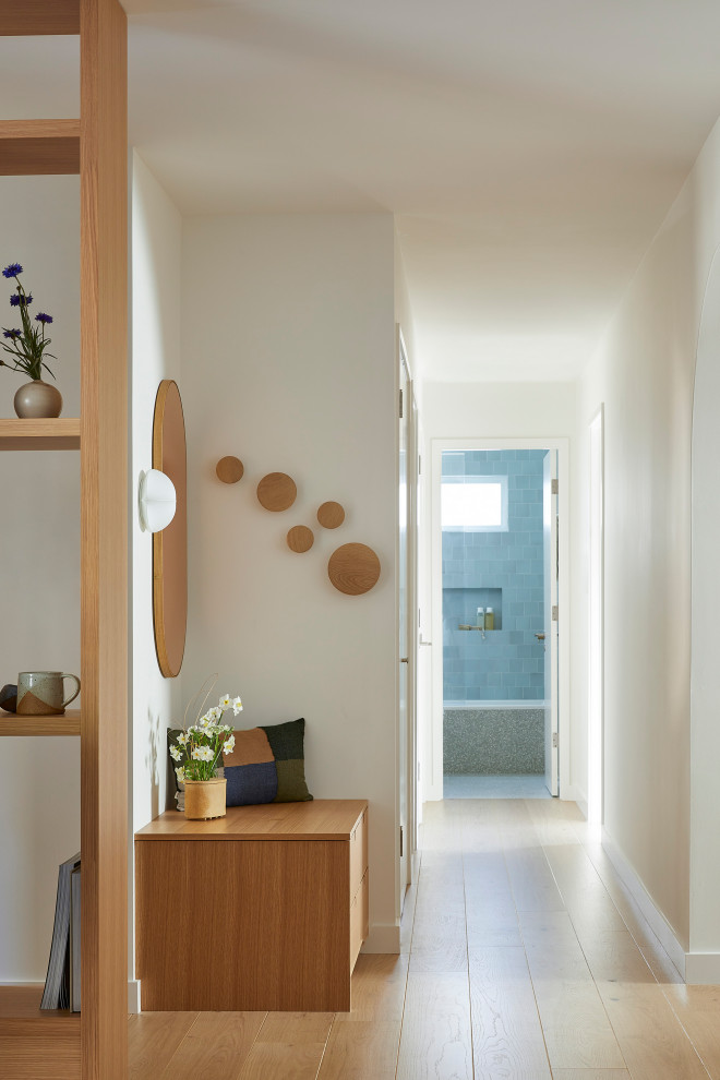 Example of a small trendy light wood floor and brown floor hallway design in San Francisco with white walls