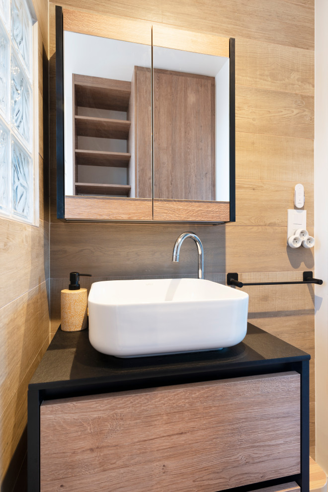 This is an example of a mid-sized contemporary master bathroom in Nancy with light wood cabinets, a curbless shower, a wall-mount toilet, wood-look tile, wood-look tile, laminate benchtops, black benchtops, a single vanity and a floating vanity.