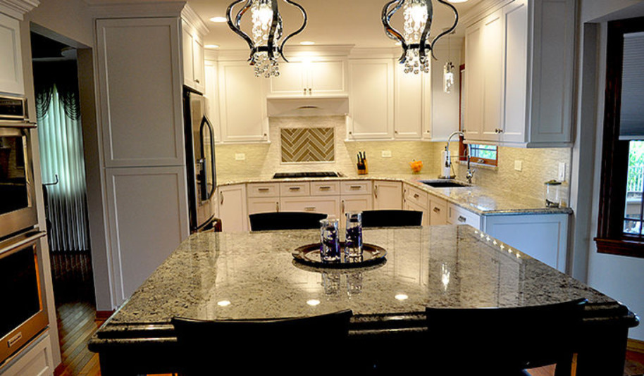 Kitchen - mid-sized transitional u-shaped medium tone wood floor and brown floor kitchen idea in Chicago with an undermount sink, recessed-panel cabinets, white cabinets, granite countertops, stainless steel appliances, an island and multicolored countertops