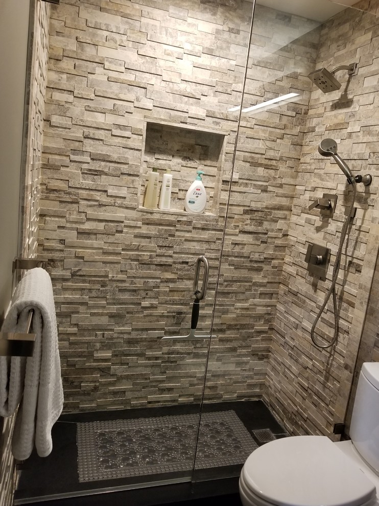 Photo of a mid-sized transitional 3/4 bathroom in Miami with recessed-panel cabinets, grey cabinets, a one-piece toilet, gray tile, stone tile, grey walls, an undermount sink, granite benchtops and black floor.