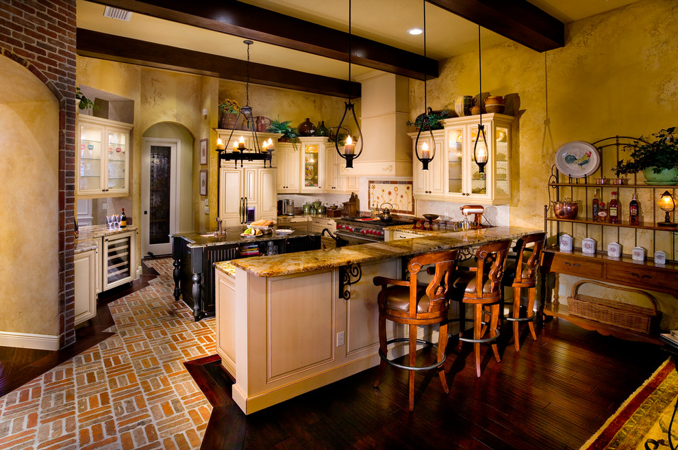 Inspiration for a large country u-shaped open plan kitchen in Tampa with a farmhouse sink, raised-panel cabinets, light wood cabinets, granite benchtops, beige splashback, stone tile splashback, panelled appliances, brick floors and with island.