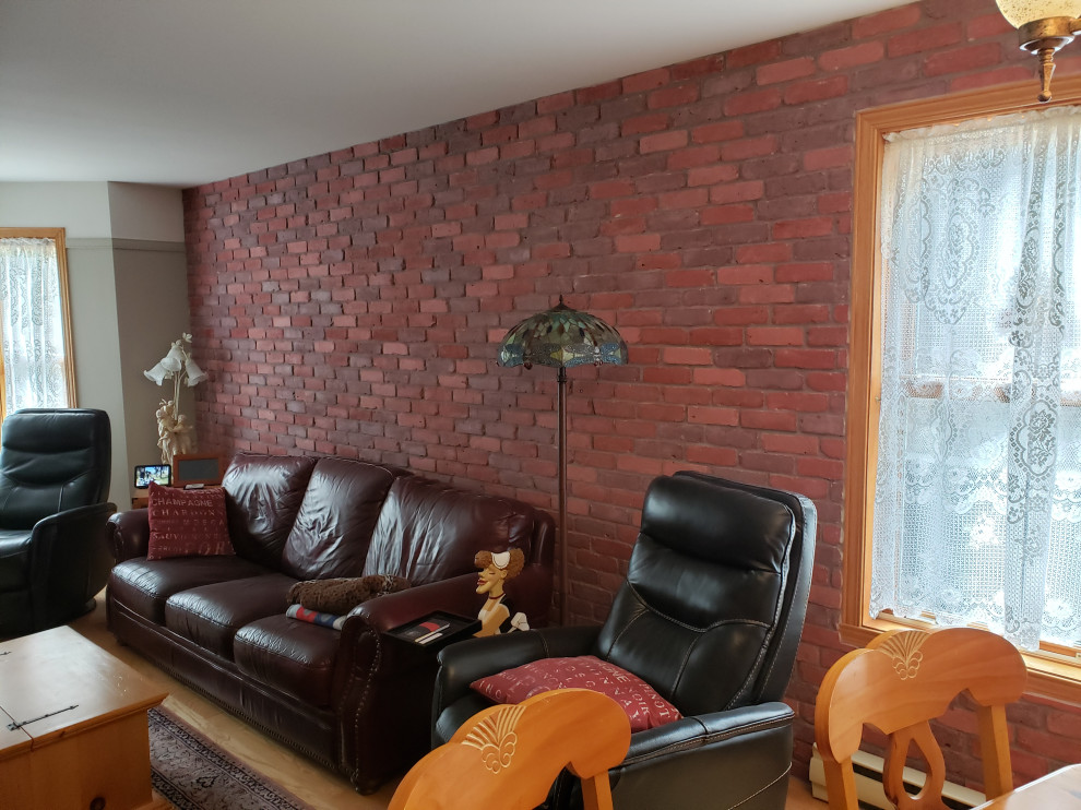 Esempio di un soggiorno aperto con pareti rosse, parquet chiaro, pavimento marrone e pareti in mattoni