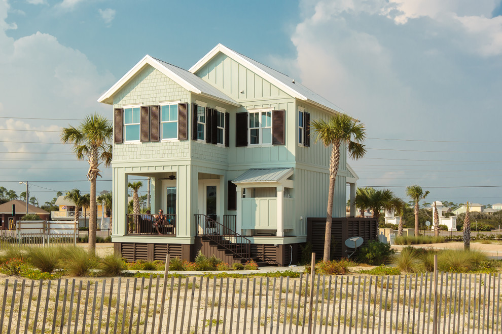 Inspiration for a mid-sized beach style two-storey green exterior in Miami with wood siding.