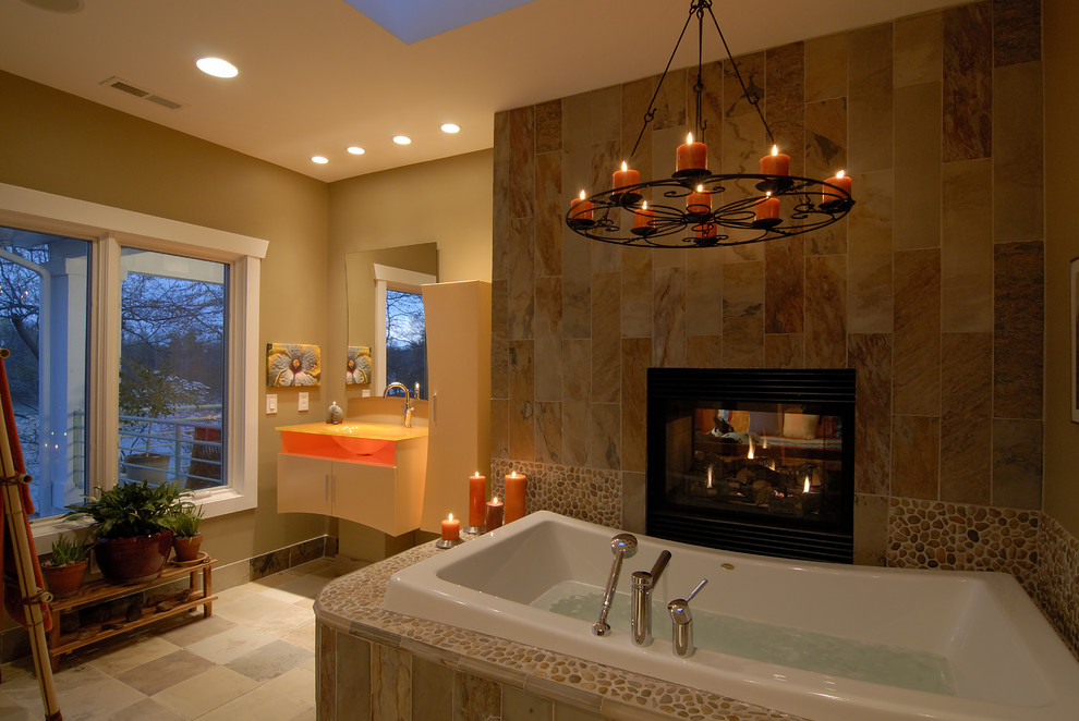 Inspiration for a large eclectic master bathroom in Charlotte with a drop-in tub, beige walls, ceramic floors, an integrated sink, glass benchtops, beige floor, flat-panel cabinets, light wood cabinets, beige tile and ceramic tile.