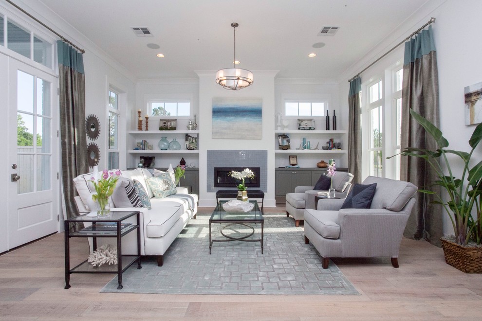 Photo of a mid-sized transitional formal open concept living room in New Orleans with white walls, light hardwood floors, a standard fireplace, a tile fireplace surround, no tv and beige floor.