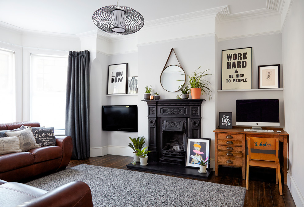 Mid-sized traditional enclosed living room in London with grey walls, dark hardwood floors, a standard fireplace, a metal fireplace surround and a wall-mounted tv.