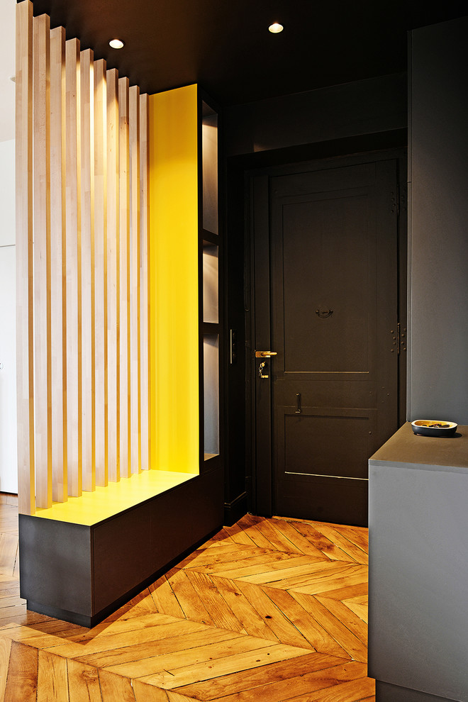 This is an example of a small transitional front door in Lyon with grey walls, light hardwood floors, a single front door and a gray front door.