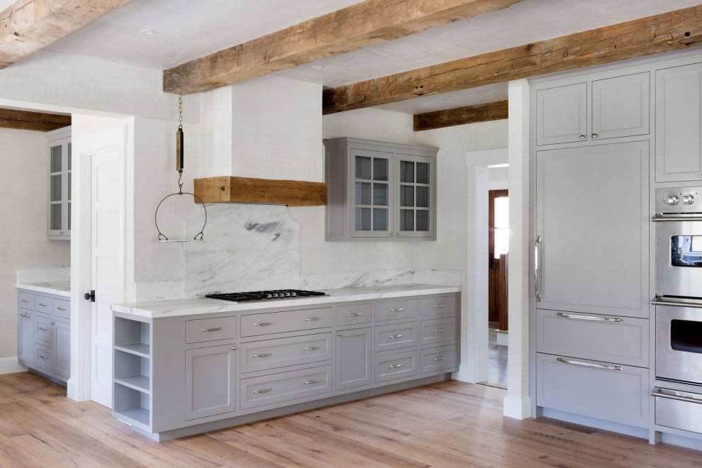 Design ideas for a large country kitchen pantry in Boston with marble benchtops, marble splashback and medium hardwood floors.