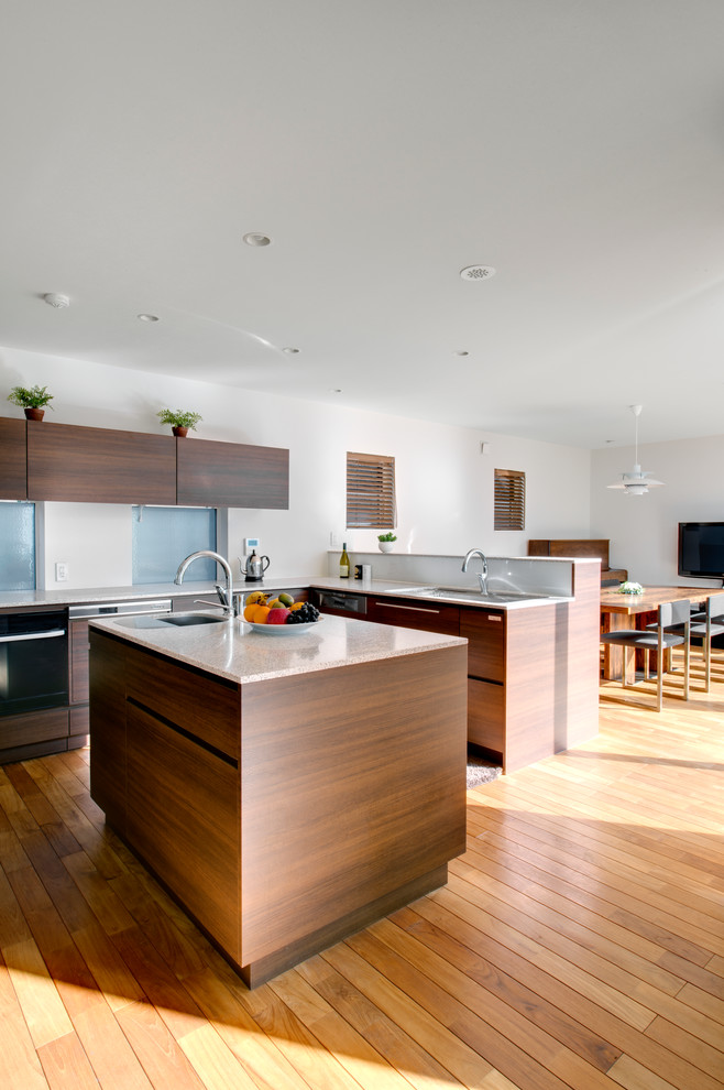 This is an example of a mid-sized contemporary l-shaped open plan kitchen in Tokyo with an undermount sink, flat-panel cabinets, medium wood cabinets, stainless steel appliances, medium hardwood floors and with island.