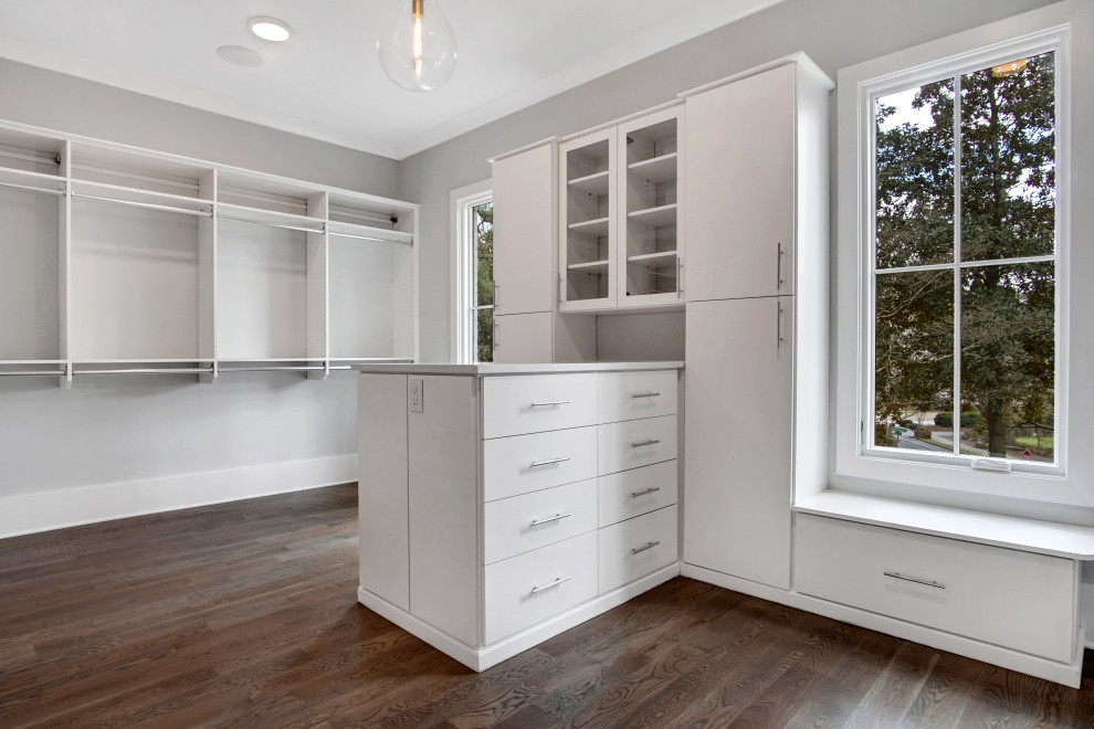 Large transitional gender-neutral walk-in wardrobe in Atlanta with flat-panel cabinets, white cabinets, medium hardwood floors and grey floor.