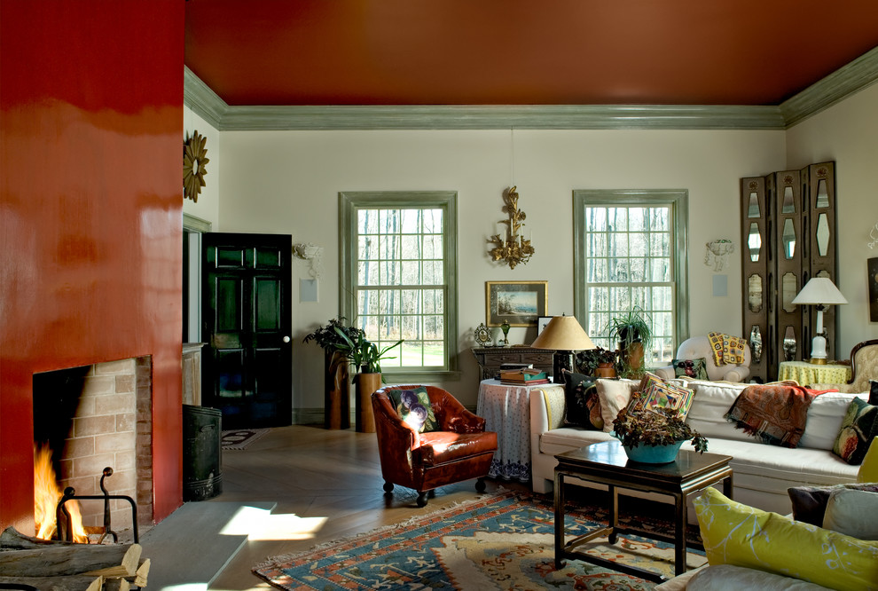 Traditional living room in New York with red walls and medium hardwood floors.