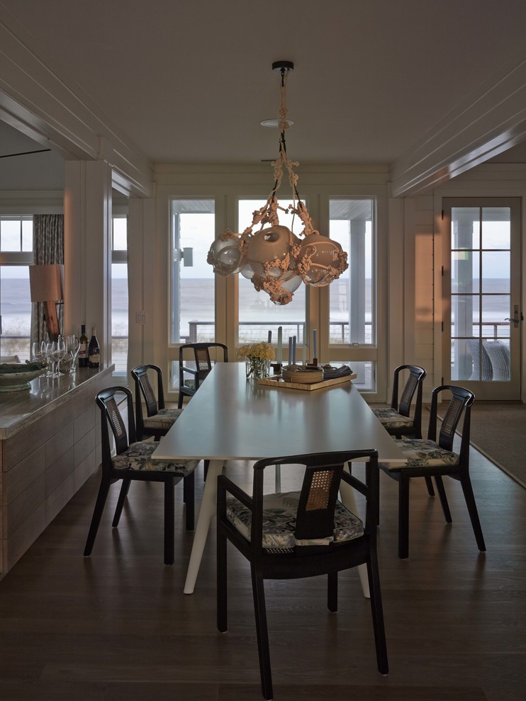 Large beach style dining room in Wilmington with white walls and light hardwood floors.